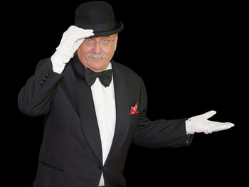 Portrait of man wearing hat against black background