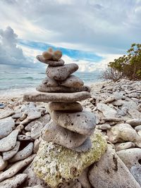 Stack of stones on beach against sky