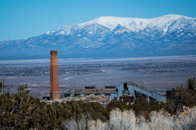 Scenic view of mountain against sky with building