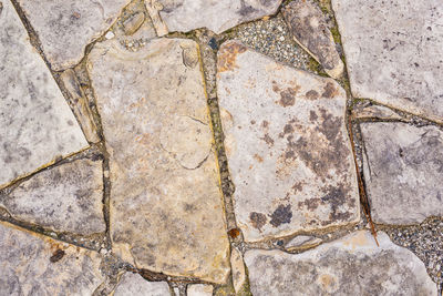 High angle view of stone wall with shadow on footpath