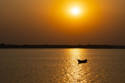 Silhouette boat in sea against sky during sunset