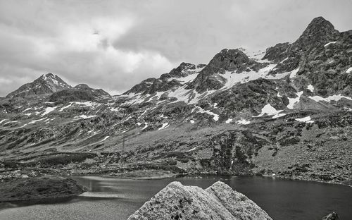 Scenic view of lake by mountains against sky