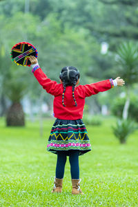 Rear view of woman standing on field