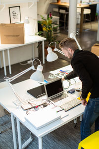 High angle view of young businessman working at desk in creative office