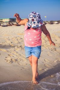 Low section of child standing on beach