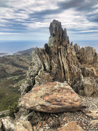 Vertical geological strata visible on a rock formation over mountain panoramic view