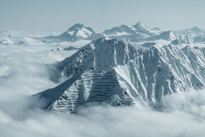 Snow covered mountain peaks reaching above a sea of clouds, gastein, austria