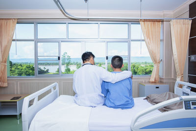 Rear view of men sitting at window