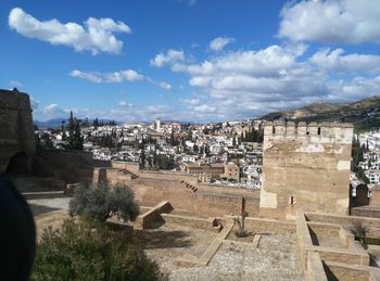 Scenic view of cityscape against cloudy sky