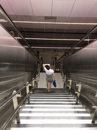 Rear view of woman walking on staircase