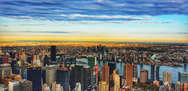 Aerial view of city buildings against sky during sunset