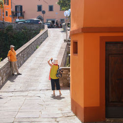 Rear view of people walking on street amidst buildings