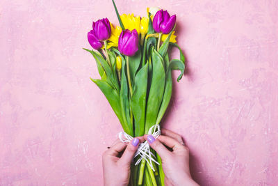 Close-up of hand holding pink flower