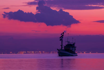 Silhouette sailboat sailing on sea against sky during sunset