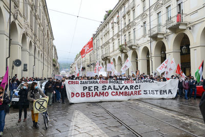 People on street against buildings in city