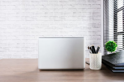 Potted plant on table against white wall
