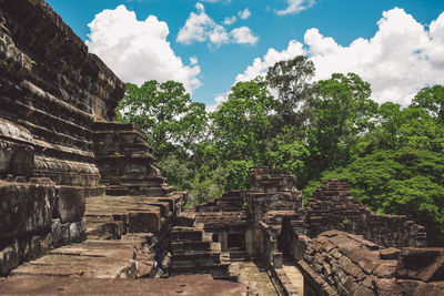 Old temple amidst trees and buildings against sky