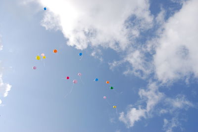 Low angle view of balloons flying against sky