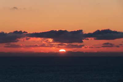 Scenic view of silhouette landscape against orange sky