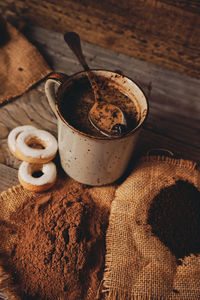 Hot chocolate by doughnuts on table