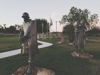 Man standing by tree in front of sky