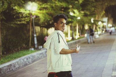 Portrait of young man looking away in city