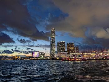 Illuminated buildings in city against sky