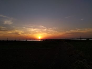 Scenic view of silhouette field against sky during sunset