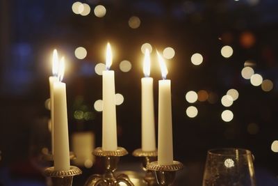 Close-up of illuminated candles on table