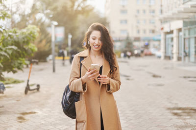 Young woman standing on street in city