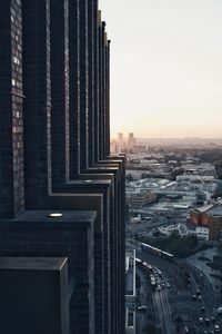 Modern buildings in city against sky during sunset