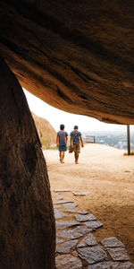 Rear view of people walking on rocks