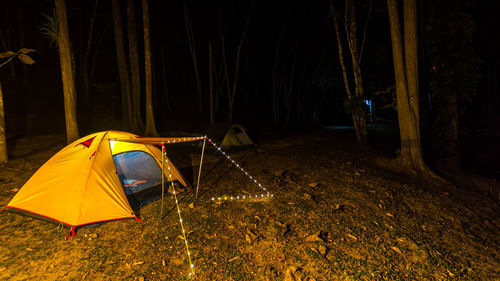 Tent on landscape against sky at night