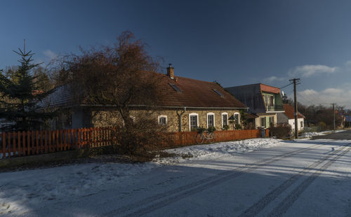 Snow covered houses against sky