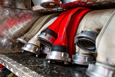 Rolled fire hoses, arranged in rows, in the glove compartment of the fire truck.