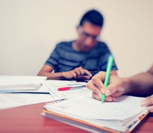 Midsection of man reading book on table