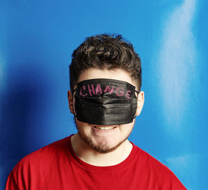 Portrait of young man wearing sunglasses against blue sky