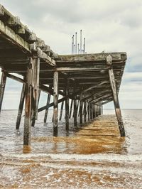 Wooden pier on sea against sky