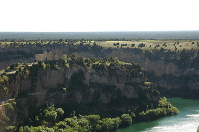 Scenic view of rock formation and river against clear sky