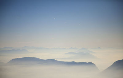 Scenic view of silhouette mountains against sky during foggy weather