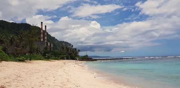 Scenic view of beach against sky next to old power plant