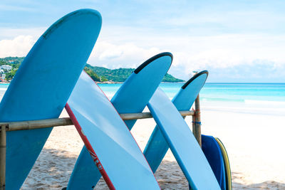 Deck chairs on beach against blue sky