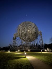 Low angle view of electricity pylon against clear blue sky