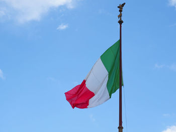 Low angle view of flag against blue sky