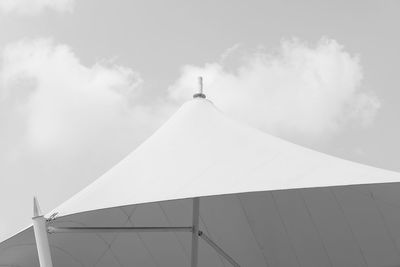 Low angle view of parasol against cloudy sky