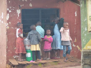 Rear view of people standing against wall