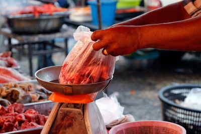 Midsection of person preparing food at market stall