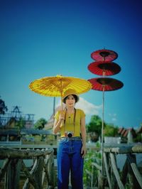 Portrait of woman standing against blue sky