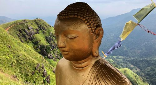 Portrait of buddha statue against mountain