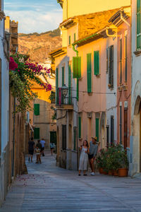 People walking on street amidst buildings in city